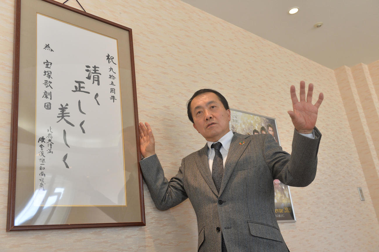 宝塚歌劇の教えを前に取材に応じる小川友次理事長