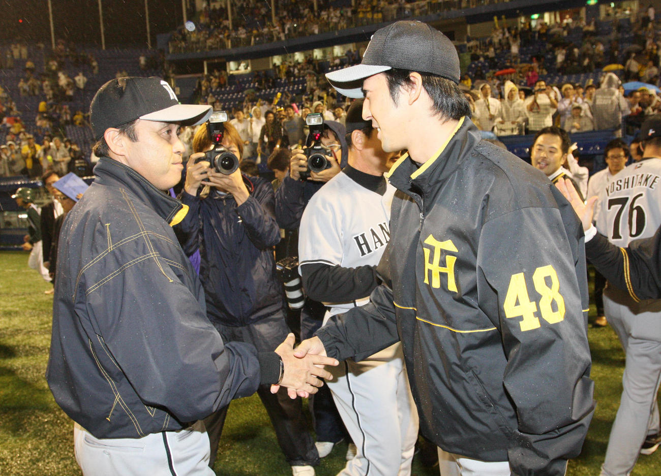 08年、岡田彰布監督と握手を交わす石川俊介さん