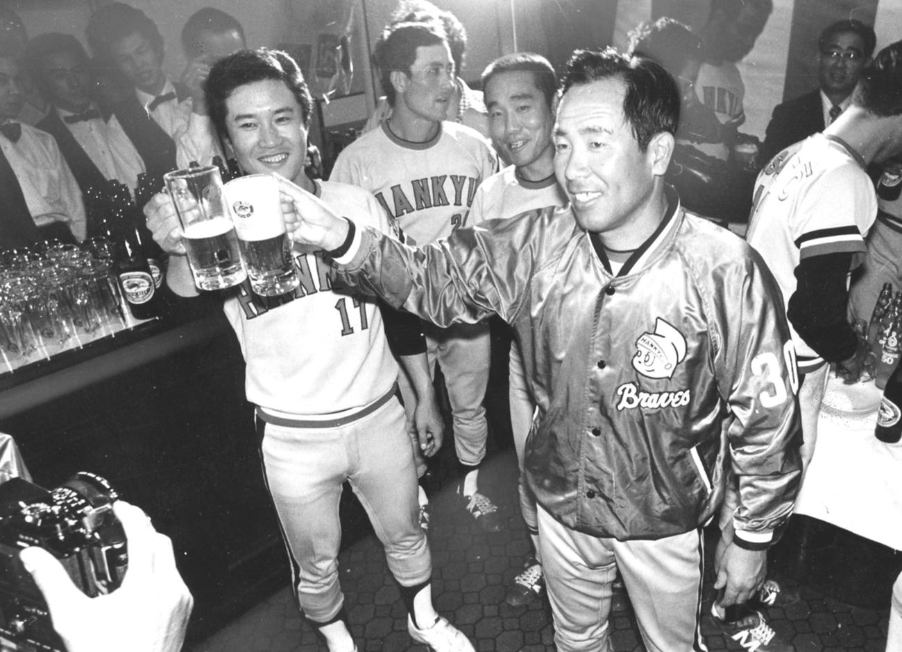77年、日本シリーズで巨人を破り３年連続日本一に輝いた阪急上田利治監督（右）は、山田久志（左）とビールで乾杯する