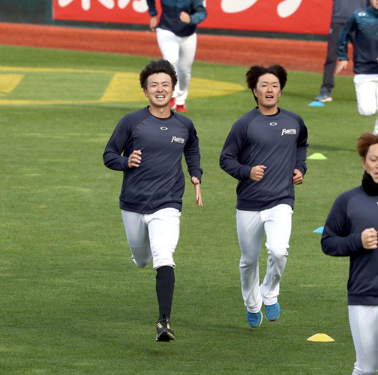 笑顔でダッシュする日本ハム上沢（左）。右は玉井（撮影・黒川智章）