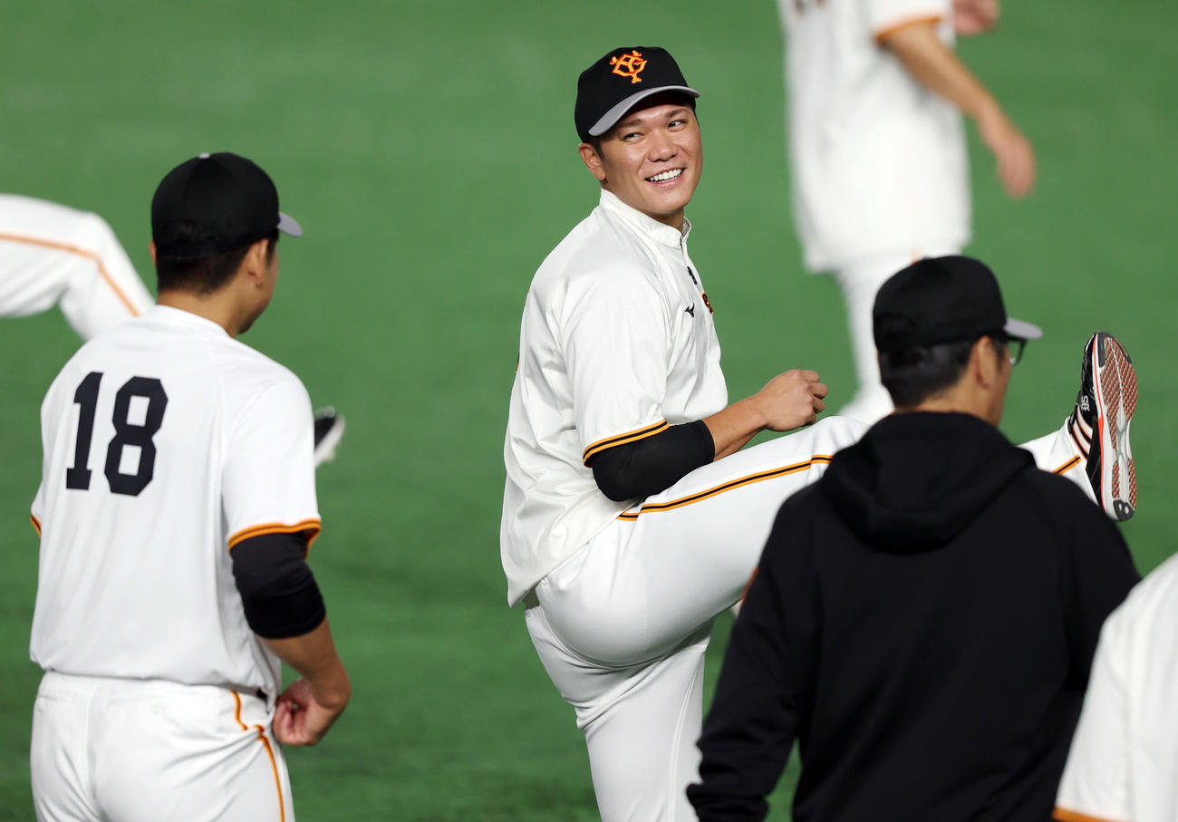 ウオーミングアップで菅野（手前）と談笑する坂本（撮影・狩俣裕三）