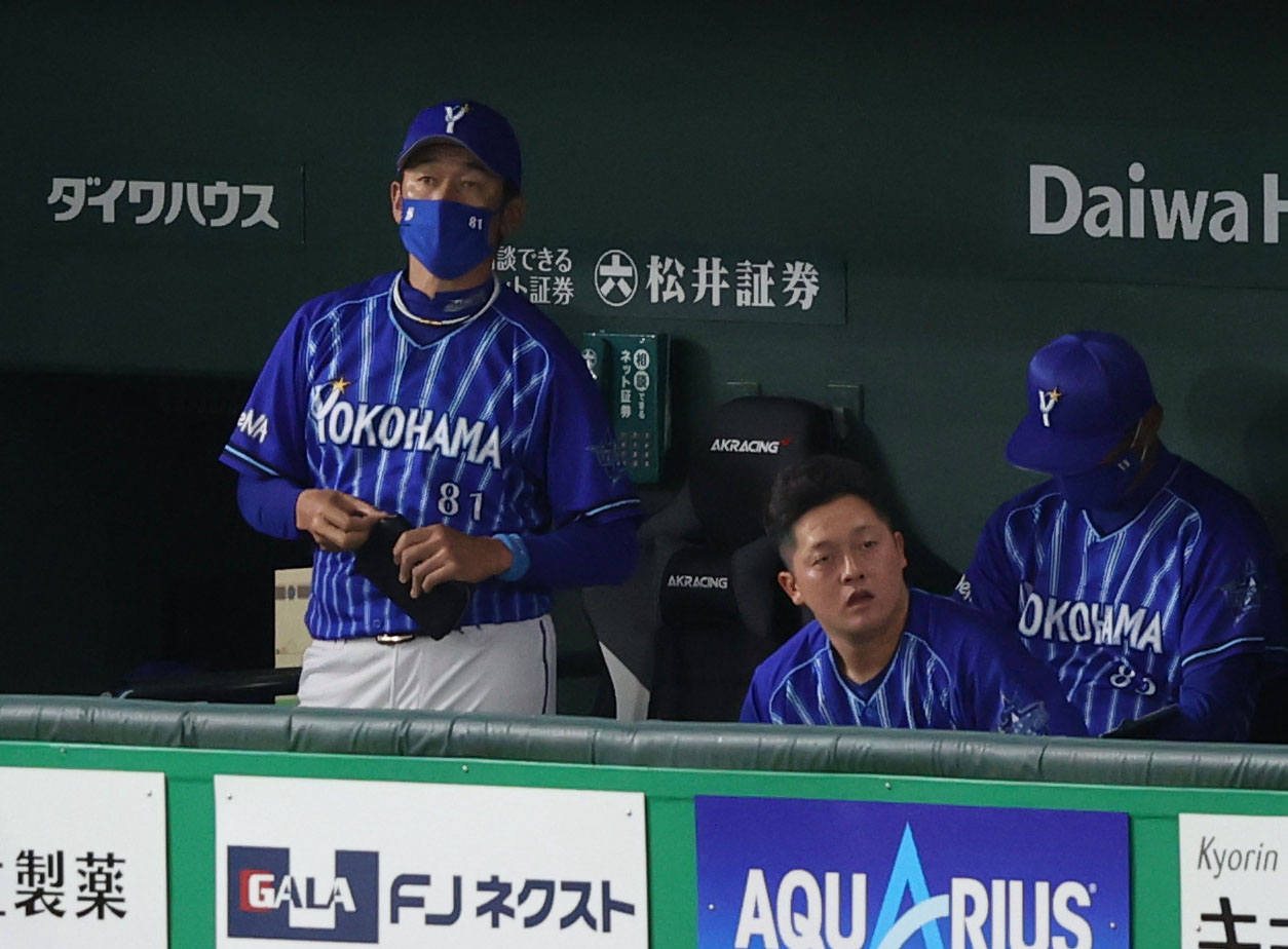 巨人対DeNA　試合後、グラウンドを見つめる三浦監督（左）。右は牧（撮影・狩俣裕三）
