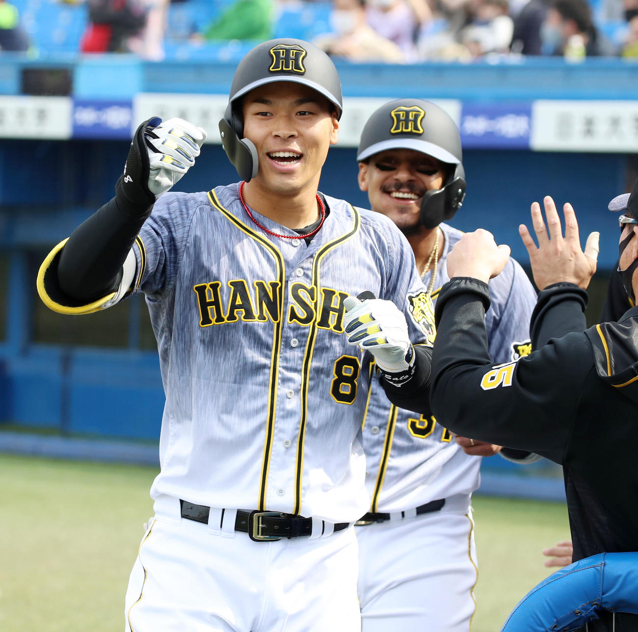 佐藤輝は中越え2点本塁打を放ちベンチ前で笑顔を見せる。右はマルテ（撮影・加藤哉）