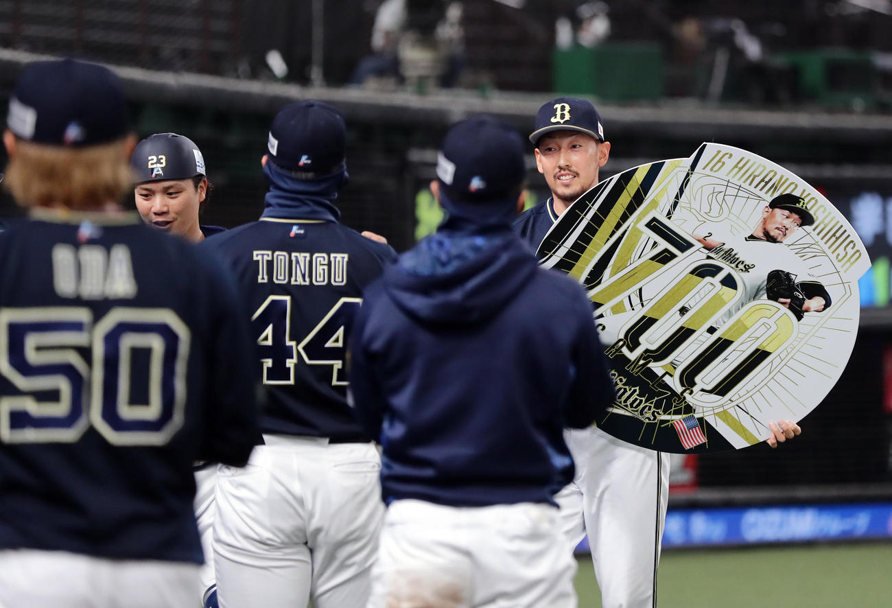 西武対オリックス　8回裏西武の攻撃を抑えたオリックス平野は、700試合登板のボードを持ちナインに迎えられる（撮影・浅見桂子）