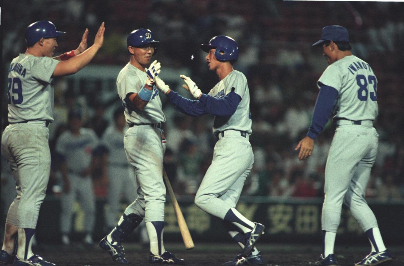 91年8月、阪神戦でプロ初安打が2点本塁打となり迎えられる矢野（右から2人目）