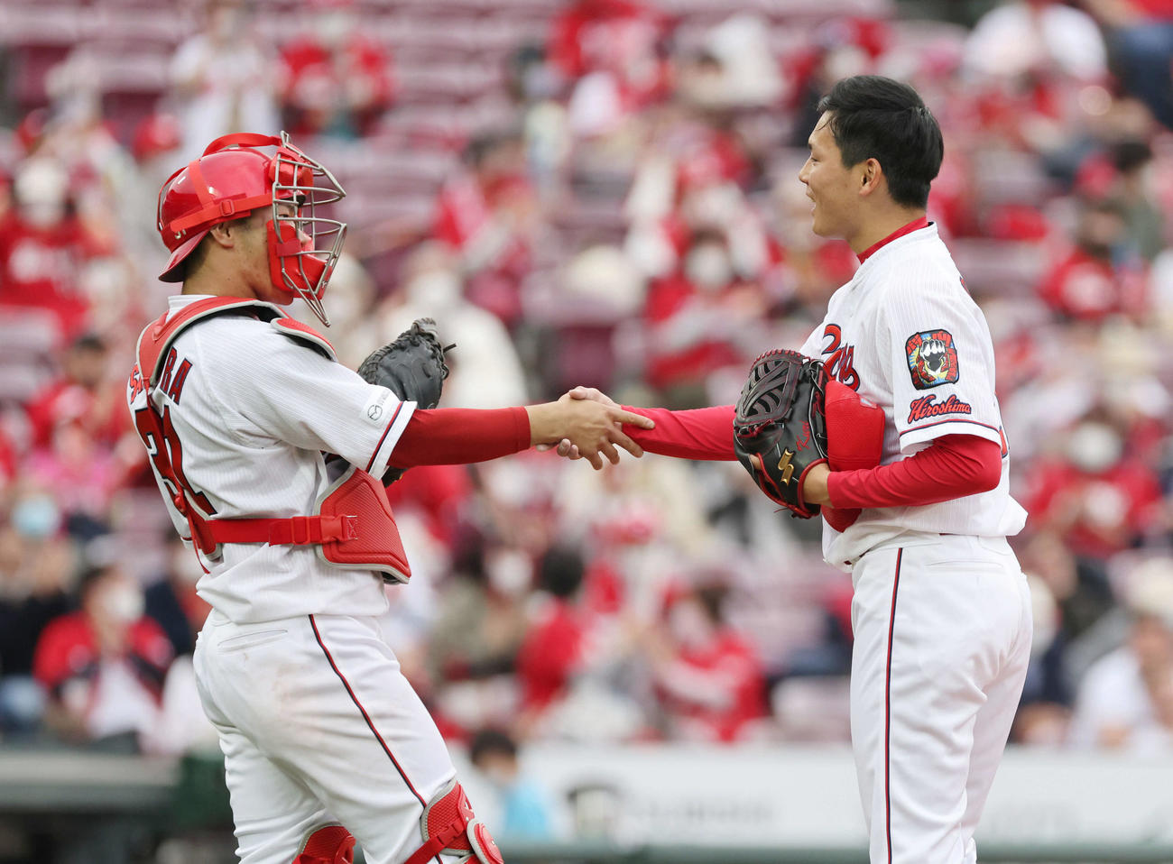 広島対中日　最後をきっちり抑えた栗林は坂倉（左）と握手（撮影・加藤孝規）