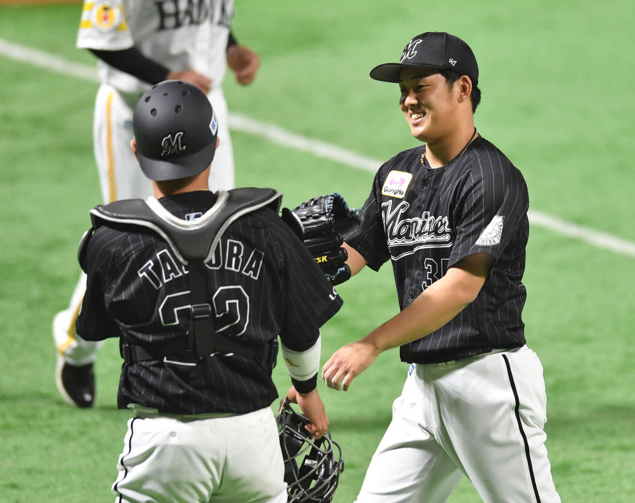 ソフトバンク対ロッテ　1回裏、3者凡退に抑え、笑顔で田村（左）とグラブタッチする鈴木（撮影・岩下翔太）
