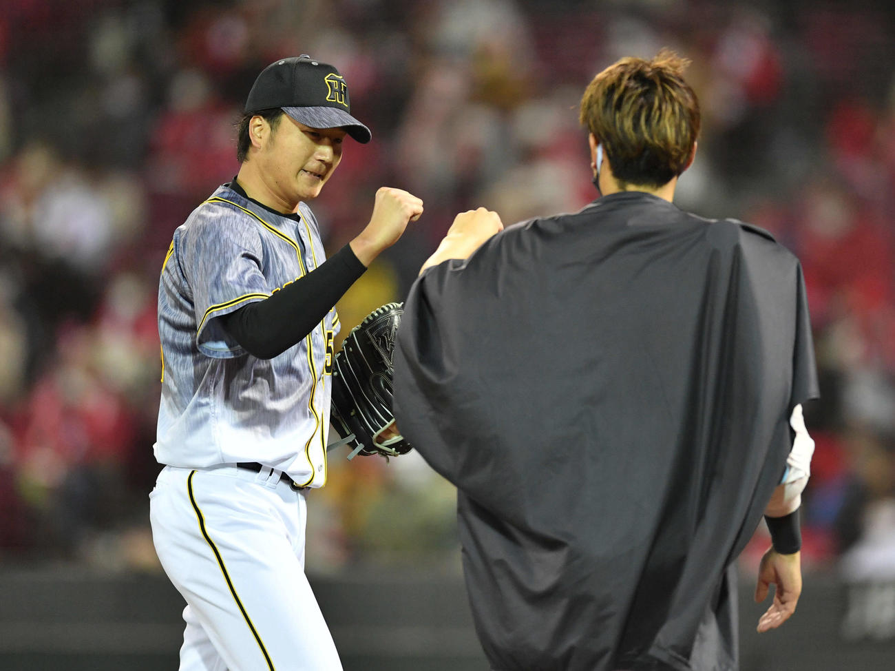 広島対阪神　8回裏、3者凡退に抑え、ベンチ前で西勇輝（右）とグータッチする小林慶祐（撮影・岩下翔太）