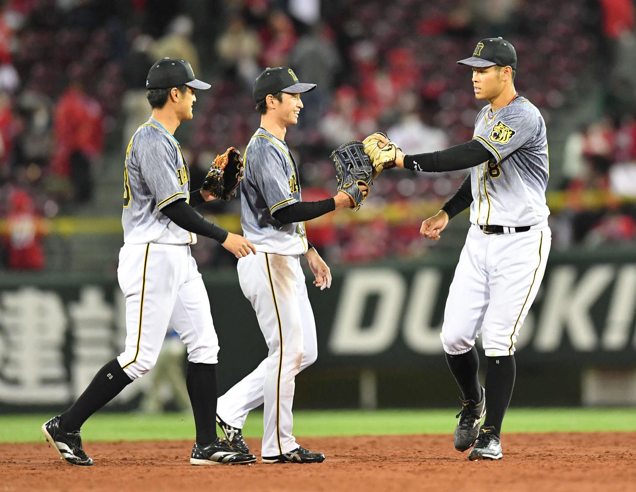 広島対阪神　広島に勝利し、板山（左）、近本（中央）とグラブタッチする佐藤輝（撮影・岩下翔太）