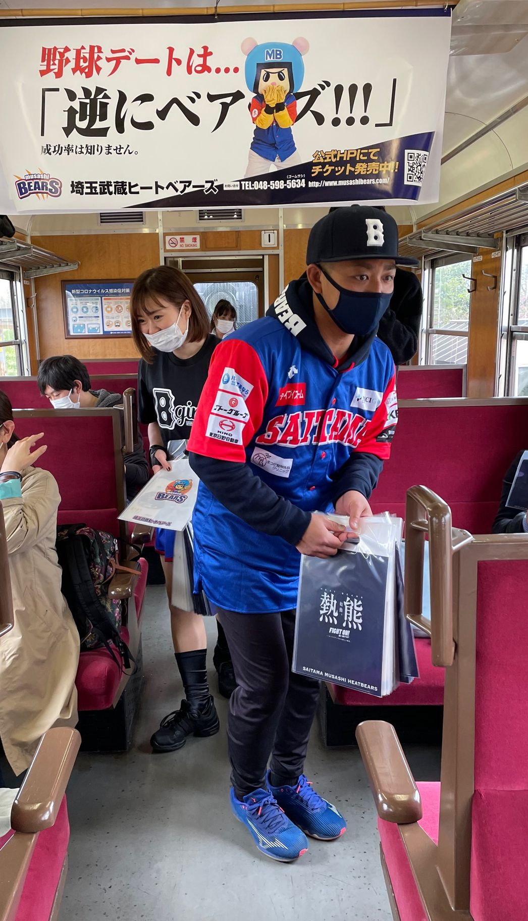 SLに乗車し、乗客に記念ファイルを配布するBC・埼玉の角監督（右）とBガールズのまこ（撮影・保坂恭子）