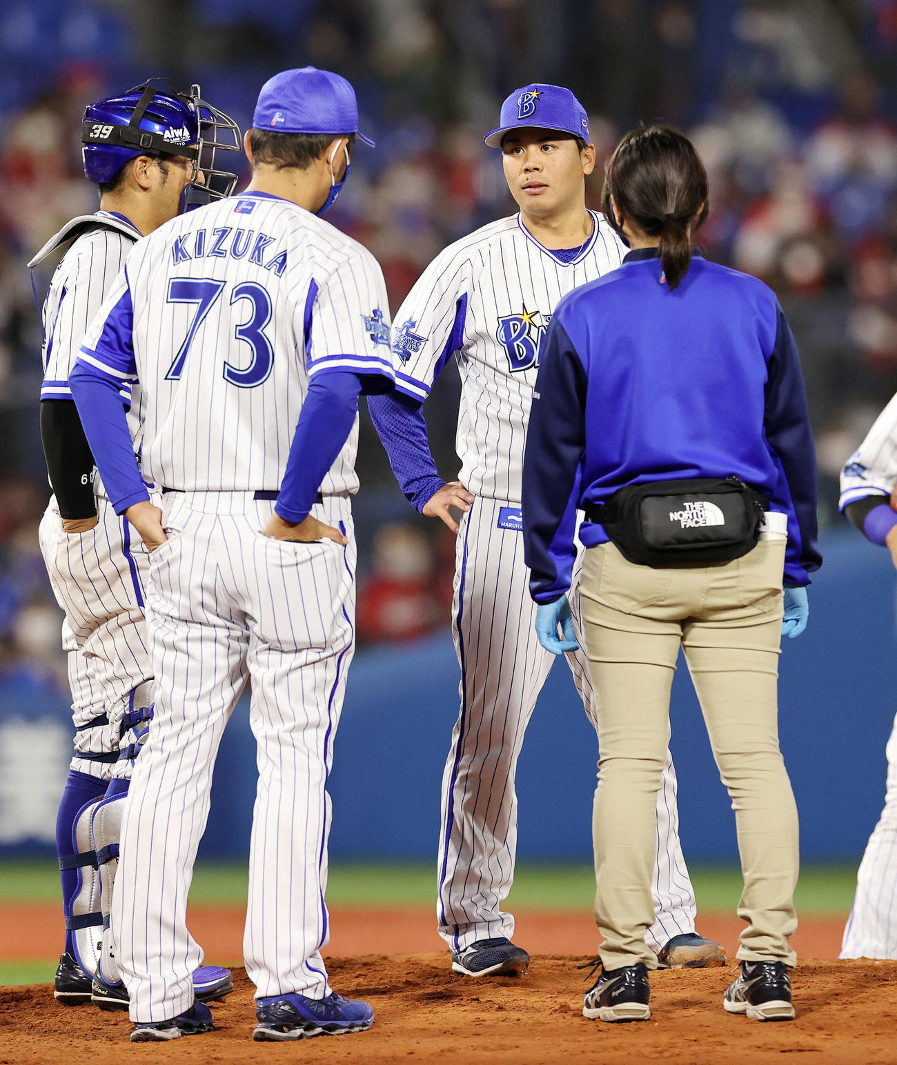 DeNA対広島　6回表、DeNA浜口遥大（後方右）は、マウンドに来た木塚コーチ（73）、トレーナー（右）と話す（撮影・鈴木正人）