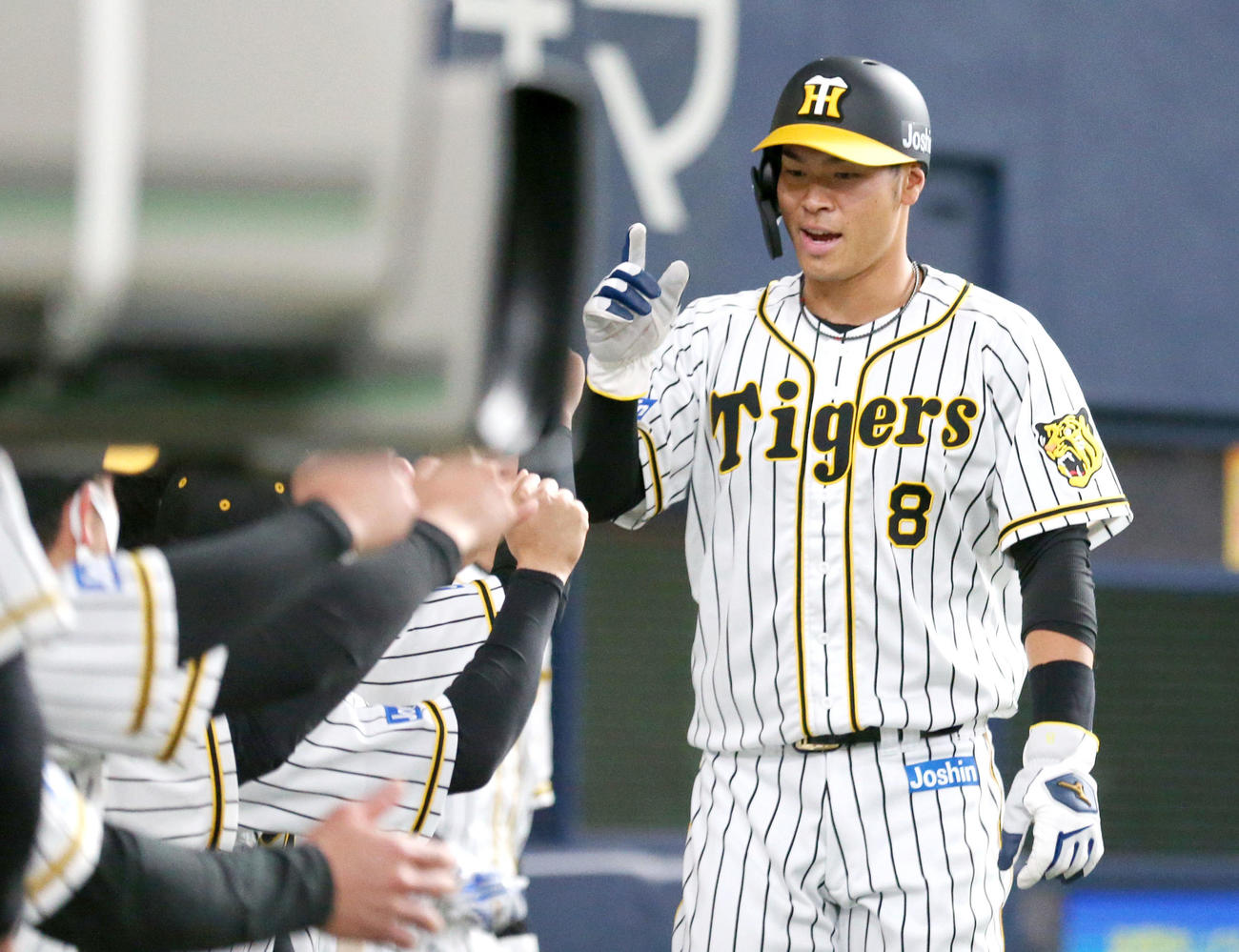 阪神対中日　2回裏阪神1死一、三塁、木浪の左適時二塁打で生還の佐藤輝はベンチの出迎えを受ける（撮影・上山淳一）