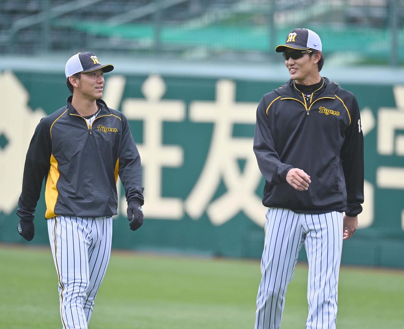 阪神藤浪晋太郎（右）と話しながらアップをする伊藤将司（撮影・上田博志）