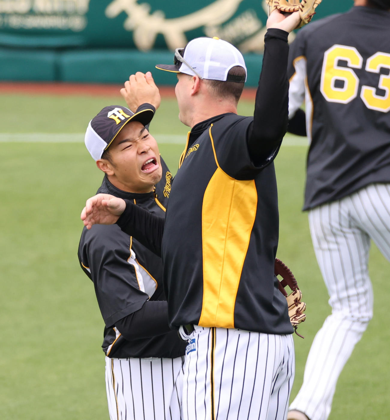 阪神対巨人　練習でサンズ（手前）とおどけた表情を見せ合う佐藤輝（撮影・清水貴仁）