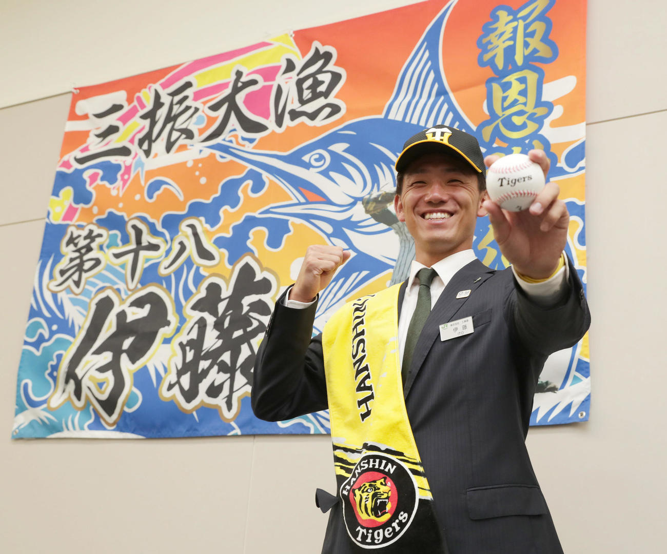 大漁旗の前で笑顔でポーズをとる伊藤将司（2020年10月26日撮影）