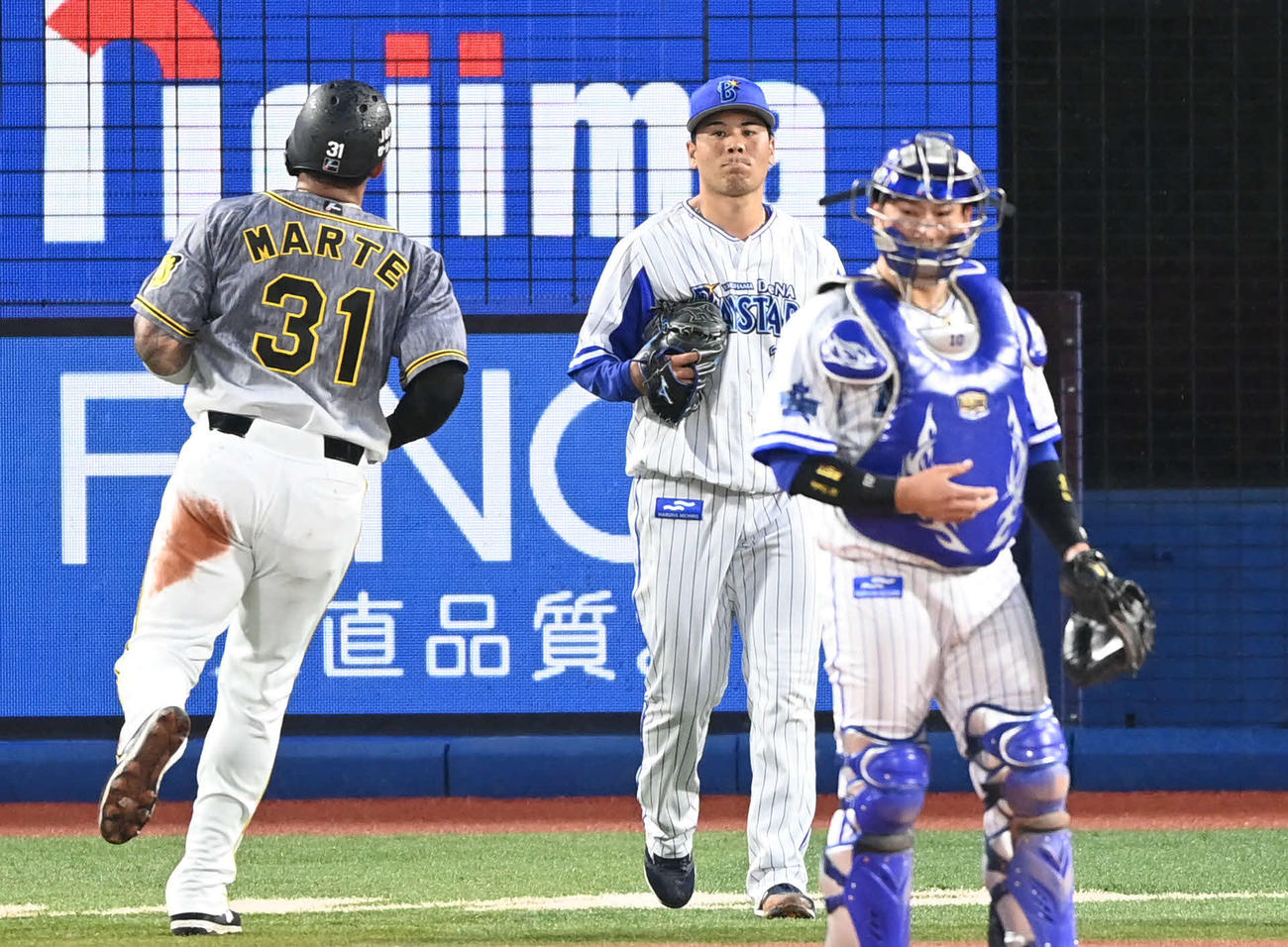 DeNA対阪神　1回表阪神1死三塁、大山に犠飛を許して悔しがる浜口（中央）。左は生還したマルテ（撮影・山崎安昭）