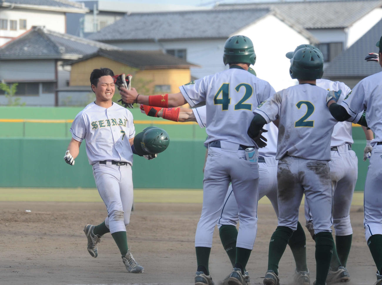 北九大対西南大　西南大9回裏2死二塁、右翼越えのサヨナラ二塁打を放ち、チームメートに駆け寄る中本（左）（撮影・浦田由紀夫）