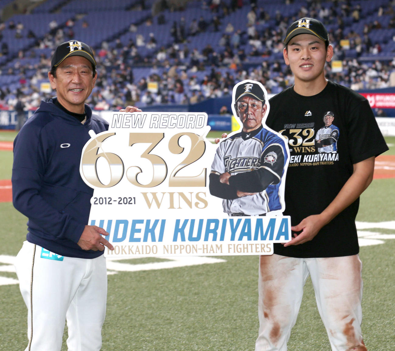 オリックス対日本ハム　球団最多632勝を達成した日本ハム栗山監督（左）は殊勲打の野村と記念ボードを手に笑顔を見せる（撮影・上山淳一）