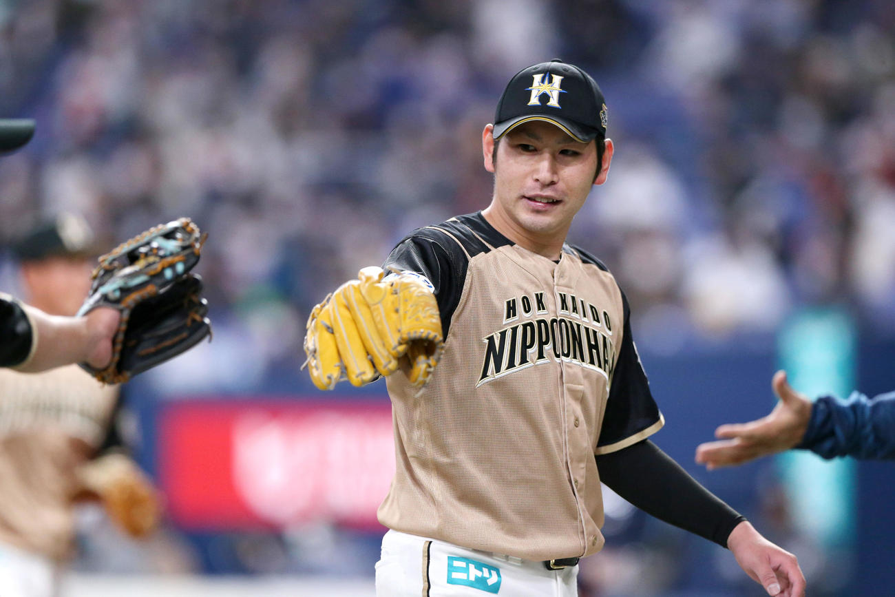 オリックス対日本ハム　日本ハム加藤は8回を投げ終えベンチのナインとグラブタッチする（撮影・上山淳一）