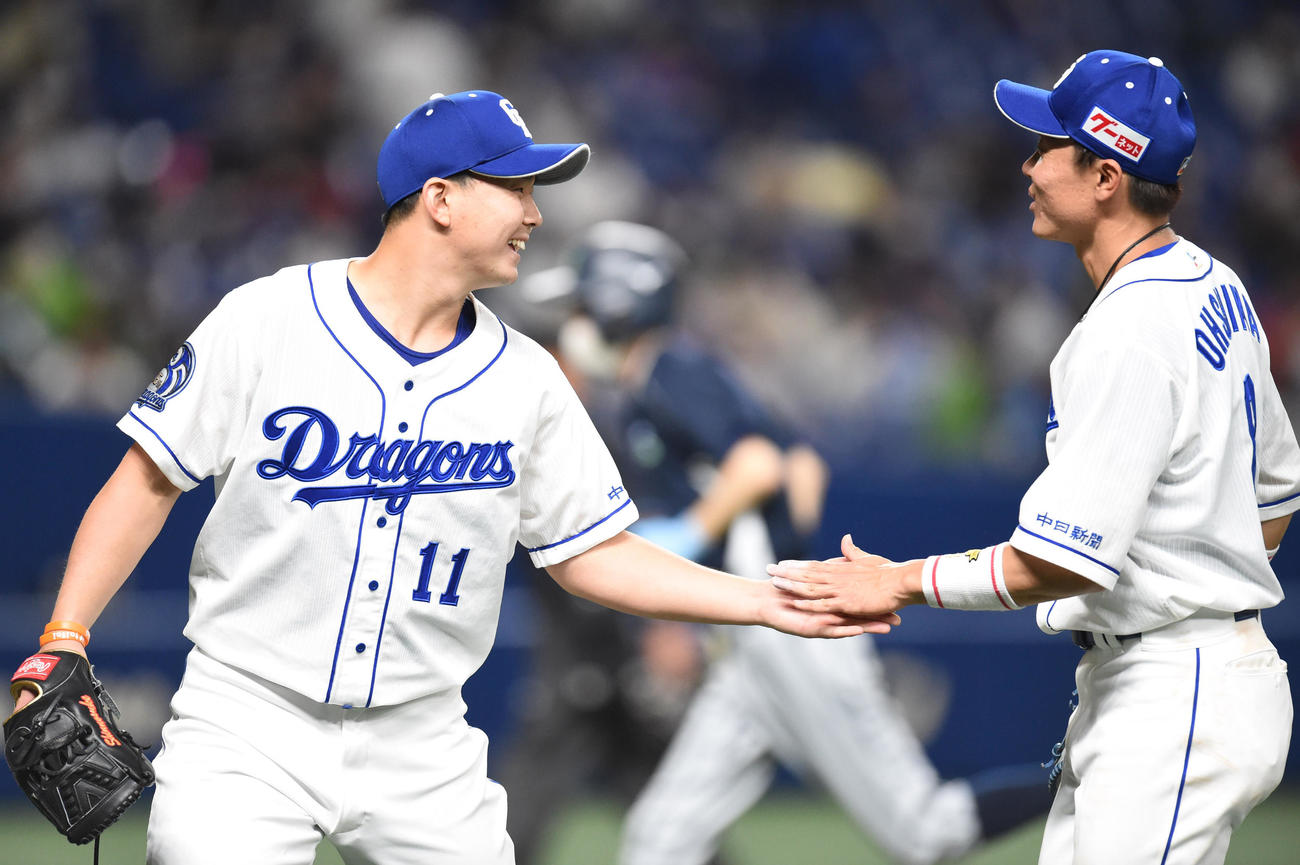 中日対ヤクルト　4回表ヤクルト攻撃終了、大島（右）と笑顔でタッチを交わしベンチへ戻る小笠原（左）（撮影・森本幸一）
