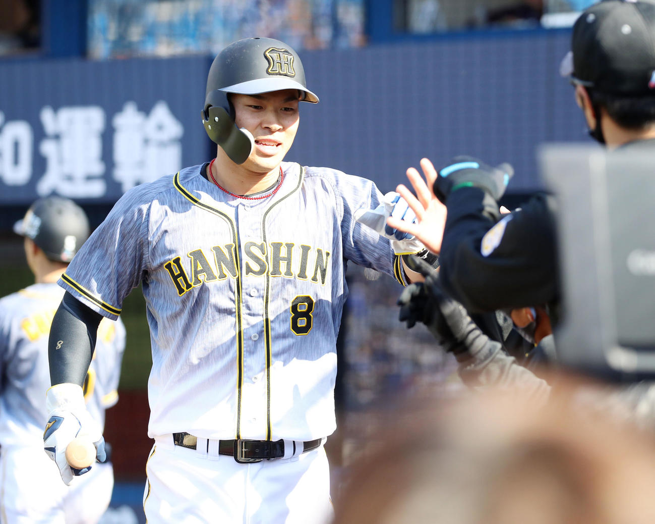 DeNA対阪神　4回表阪神1死三塁、三塁走者佐藤輝明は中野拓夢の左線適時打で生還しベンチのナインとタッチする（撮影・加藤哉）