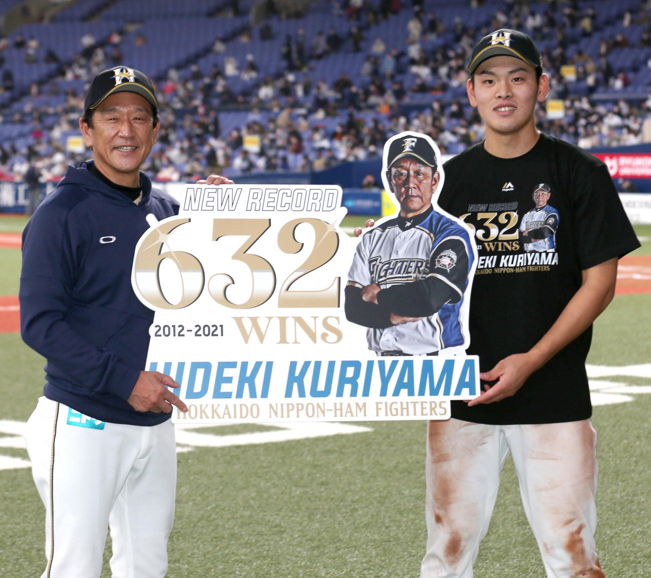 球団最多632勝を達成した日本ハム栗山監督（左）と記念ボードを手にする殊勲打の野村（2021年4月10日撮影）