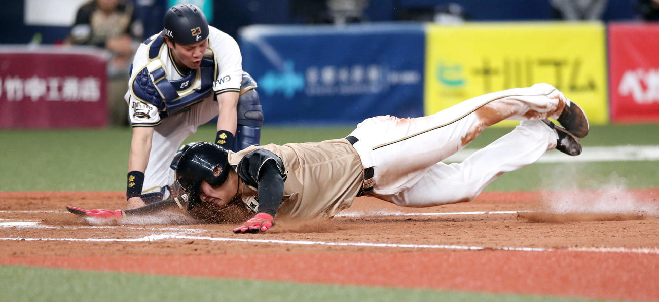10日、オリックス戦の9回に右犠飛で生還する日本ハム野村（手前）。後方は捕手伏見