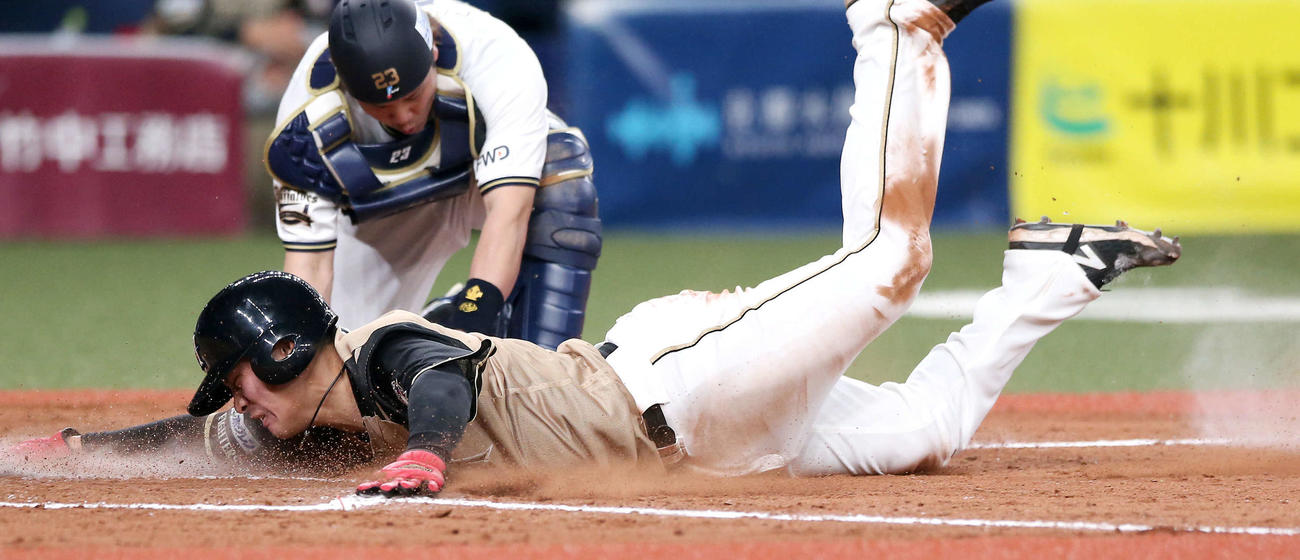 10日、オリックス戦の9回に右犠飛で生還する日本ハム野村（手前）。後方は捕手伏見