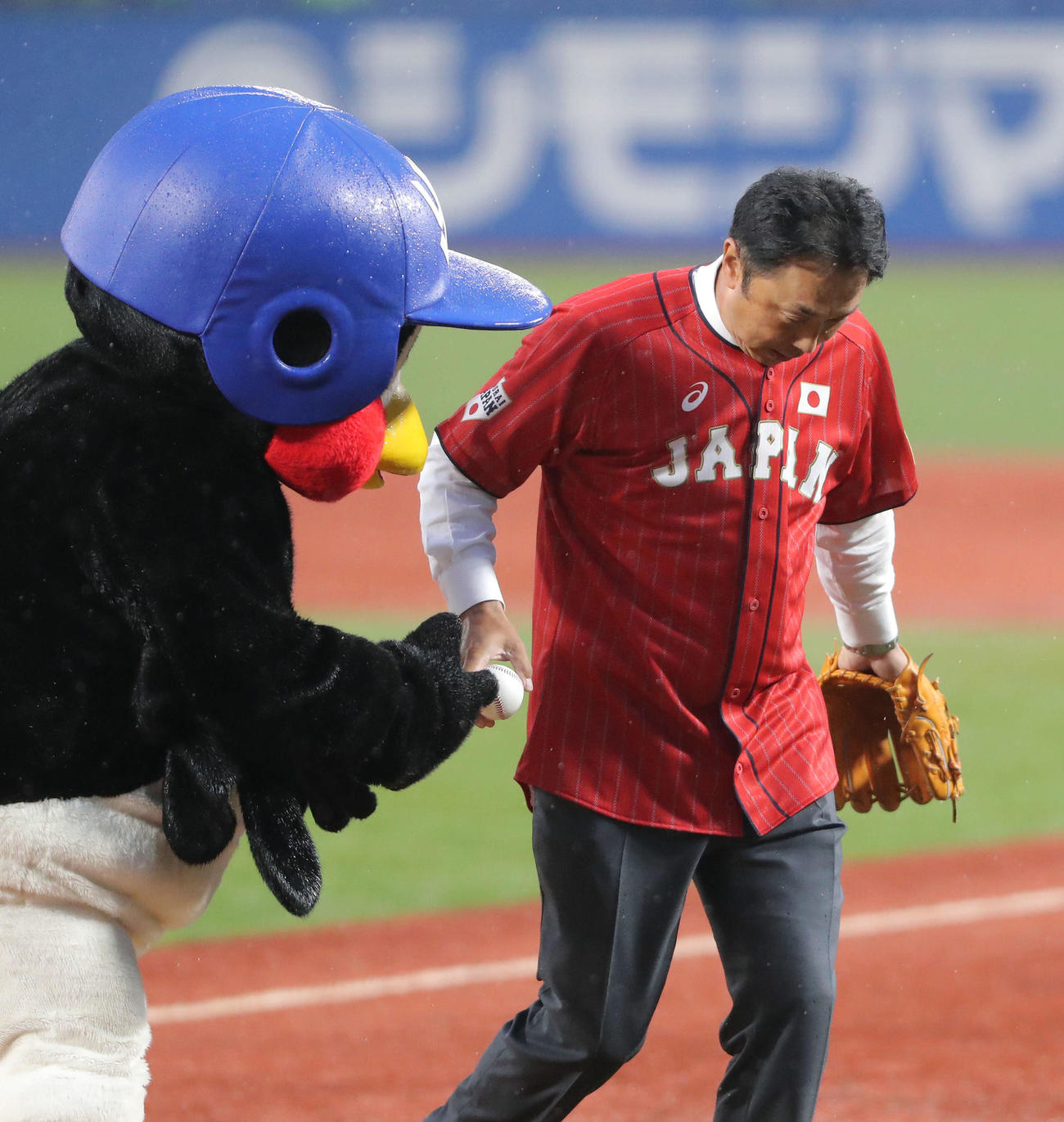 つば九郎から記念球を受け取る宮本慎也氏（撮影・河田真司）