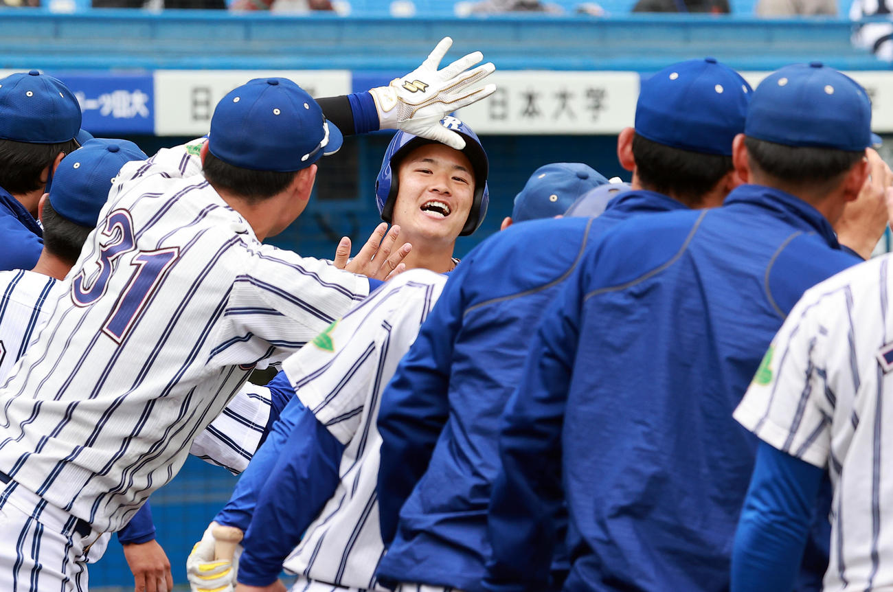 東洋大対立正大　4回裏立正大無死、奈良間（中央）は左越え先制ソロ本塁打を放ち、ナインと笑顔でハイタッチ（撮影・浅見桂子）