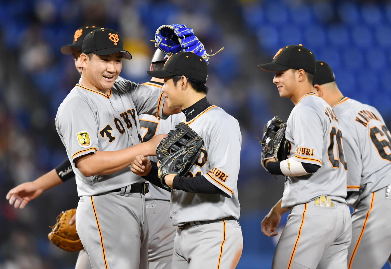 DeNA対巨人　今季初勝利を完封で飾り笑顔でナインを迎える巨人菅野（左）（撮影・横山健太）