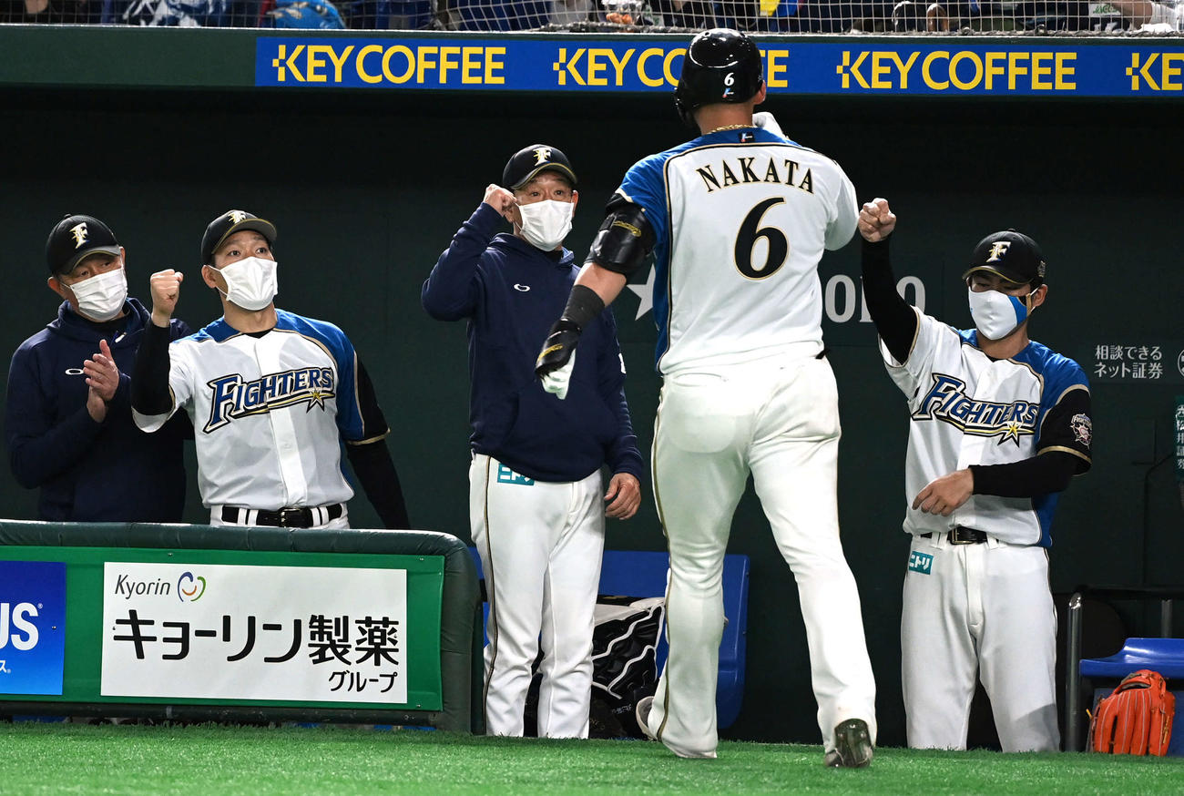 日本ハム対楽天　6回裏日本ハム2死、栗山監督（中央）はソロ本塁打を放った中田（右から2人目）とエアタッチ（撮影・山崎安昭）