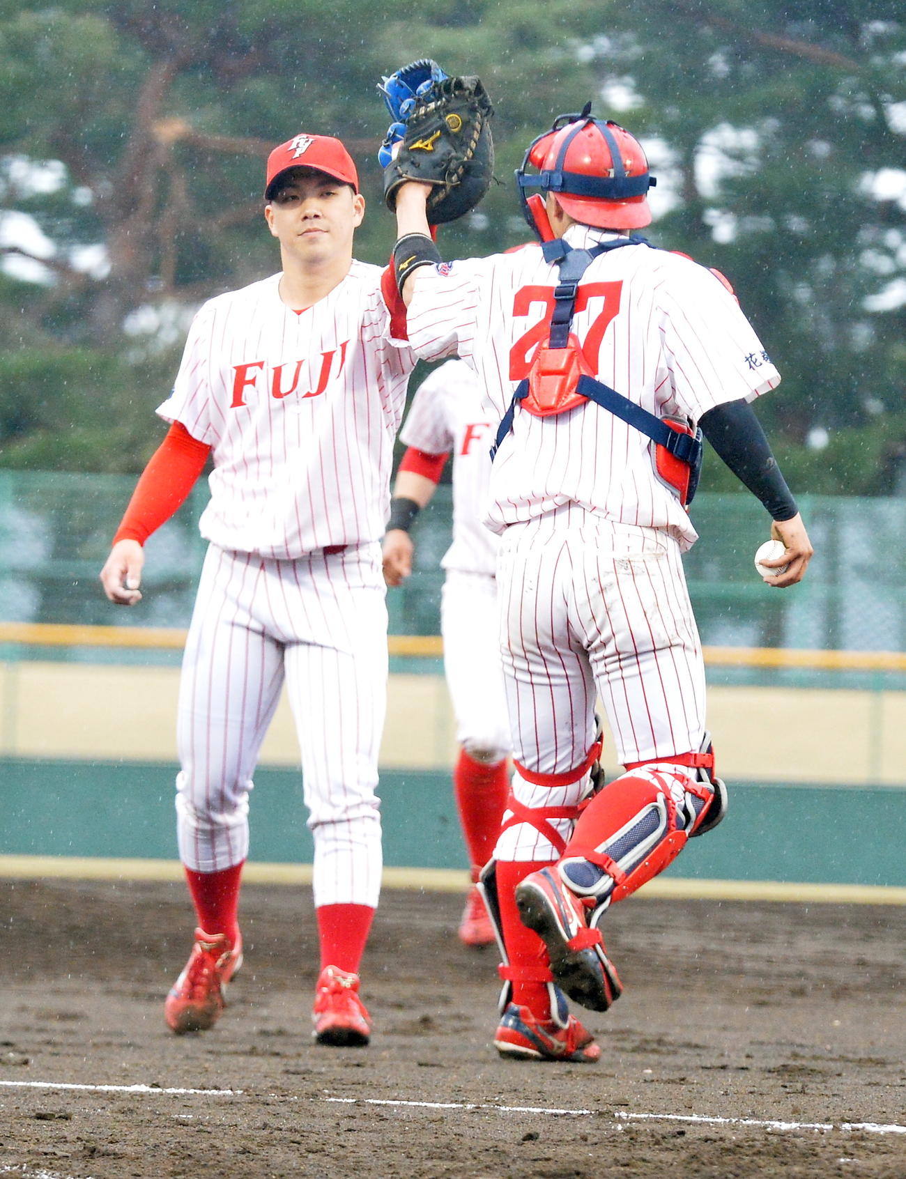 富士大対ノースアジア大　完全試合を達成し、富士大・佐藤（右）とグラブタッチする金村（撮影・佐藤究）