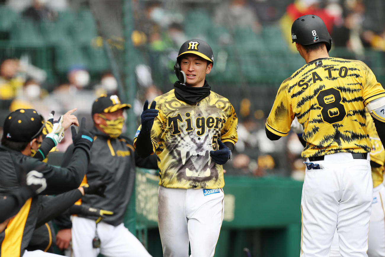 阪神対ヤクルト　3回裏阪神無死満塁、三塁走者近本は大山の右前適時打で生還しベンチのナインとエアタッチ（撮影・加藤哉）
