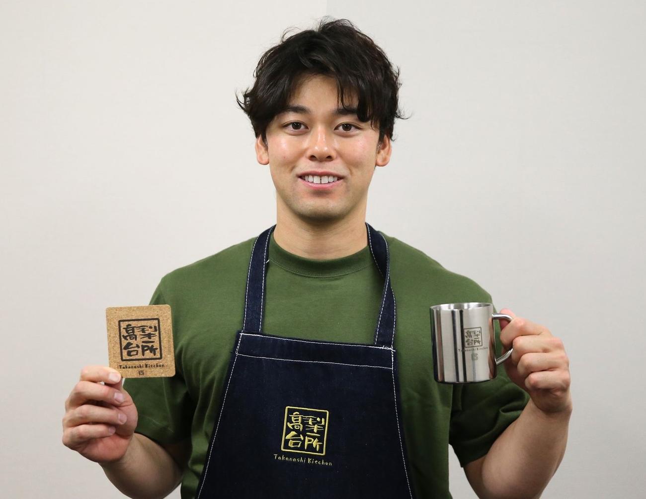 19日から発売された「たかなしきっちん」グッズを手に笑顔の巨人高梨雄平投手(球団提供)