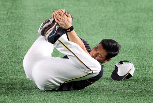 巨人対阪神　東京ドームの人工芝を確かめるようにゴロゴロとウオーミングアップをする佐藤輝（撮影・狩俣裕三）