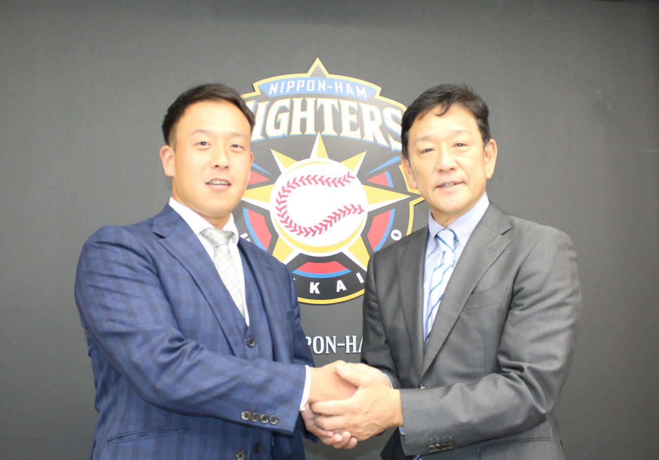 入団会見に臨んだ阪神から金銭トレードで移籍した日本ハム谷川（右は栗山監督）（撮影・木下大輔）
