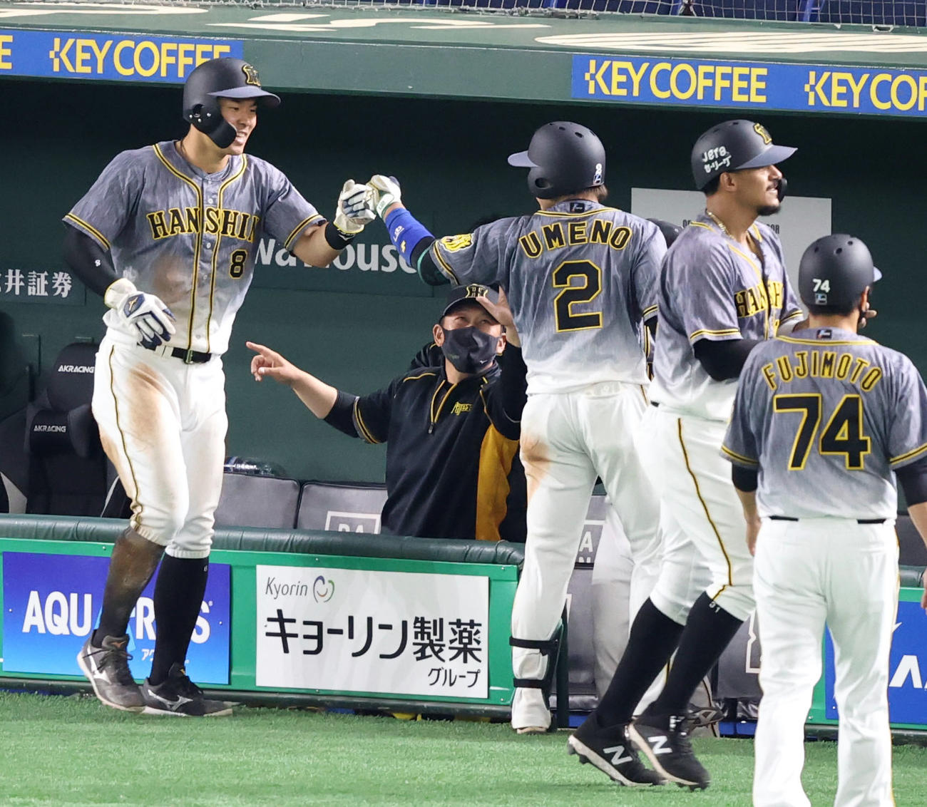 巨人対阪神　7回表を終え、この回に2点適時二塁打を放った梅野（中央）とタッチを交わす佐藤輝（撮影・狩俣裕三）