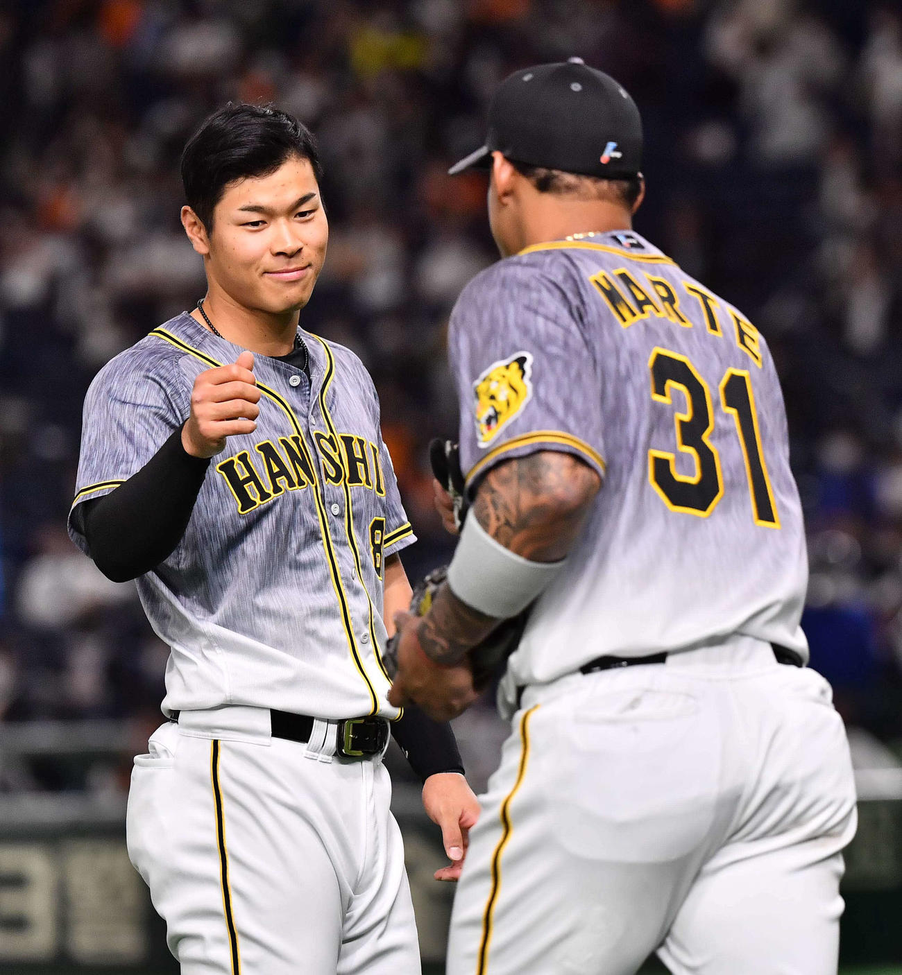 巨人対阪神　3回に適時安打を放った佐藤輝（左）はマルテとグータッチする（撮影・上田博志）