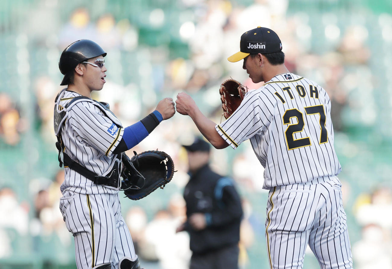 阪神対DeNA DeNAに勝利し、プロ初完投勝利を挙げた伊藤将司（右）は梅野隆太郎とグータッチ（撮影・前田充）