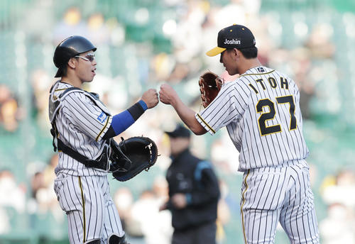 阪神対DeNA DeNAに勝利し、プロ初完投勝利を挙げた伊藤将司（右）は梅野隆太郎とグータッチ（撮影・前田充）