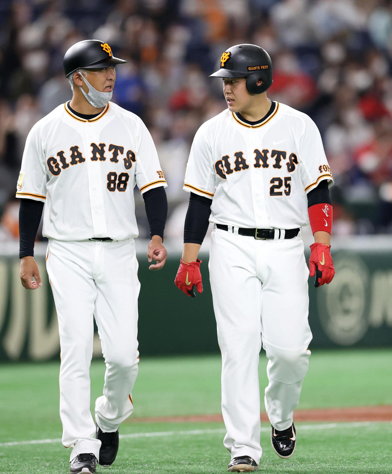 巨人対広島　1回裏巨人1死二塁、ウィーラーの左飛で二塁に戻れずアウトとなり、後藤野手チーフコーチ（左）と話をしながらベンチに戻る岡本和（撮影・狩俣裕三）