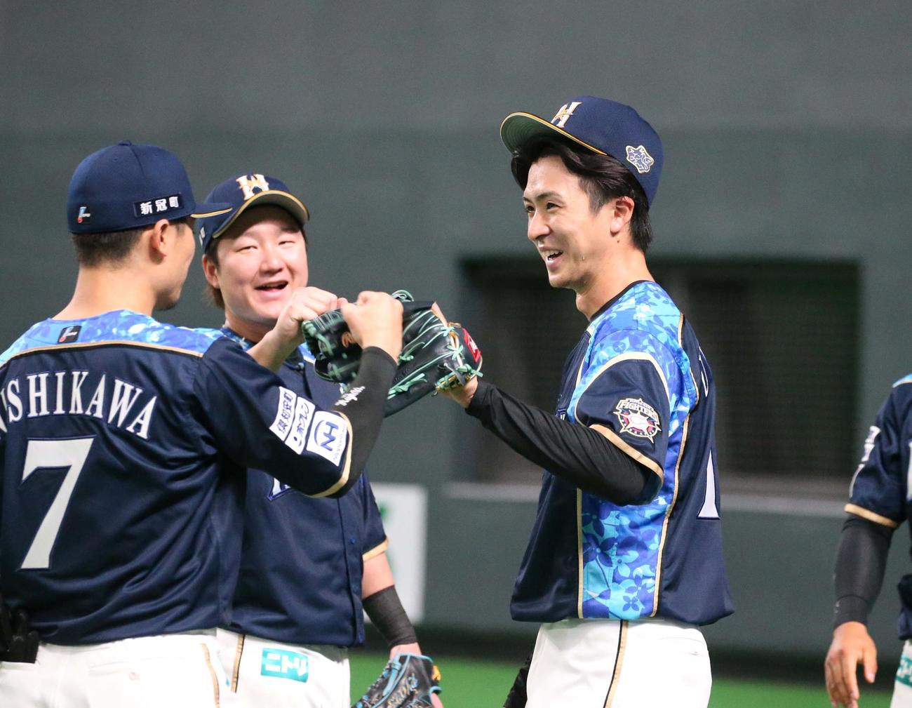 日本ハム対オリックス　7回表、好守を見せた西川を笑顔で出迎える上沢（撮影・黒川智章）