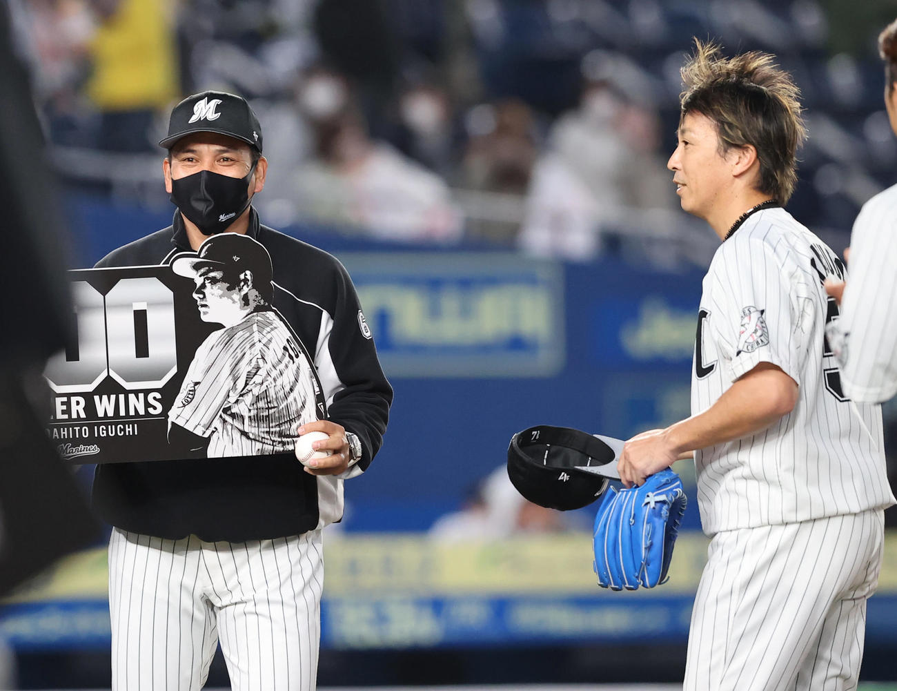 ロッテ対ソフトバンク　ソフトバンクに競り勝ち通算200勝を挙げたロッテ井口監督（左）は益田から勝利球を受け取り笑顔を見せる（撮影・垰建太）