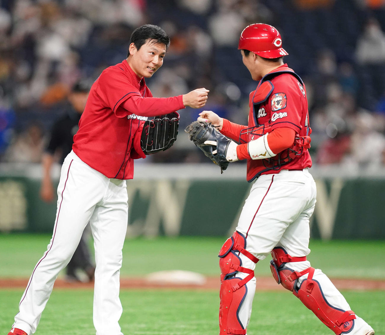 巨人対広島　巨人に勝利しタッチを交わす広島栗林（左）と会沢（撮影・鈴木みどり）