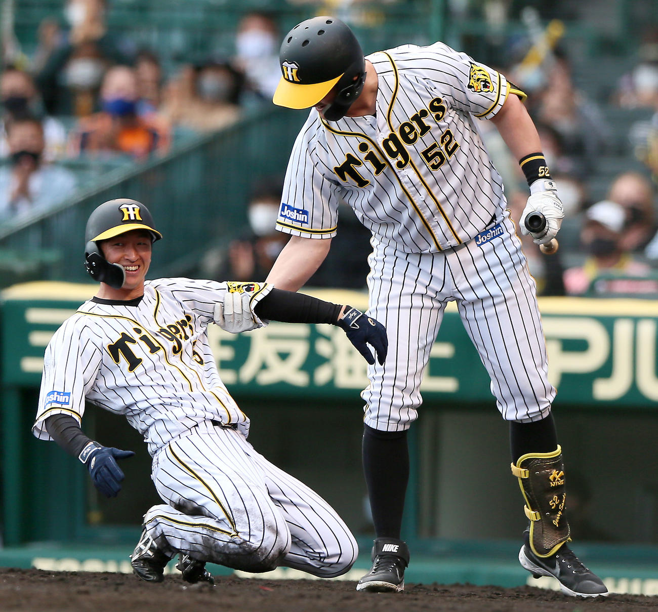 阪神対DeNA 7回裏阪神1死二、三塁、大山悠輔の中犠飛で生還の近本（左）を持ち上げるサンズ（撮影・上山淳一）