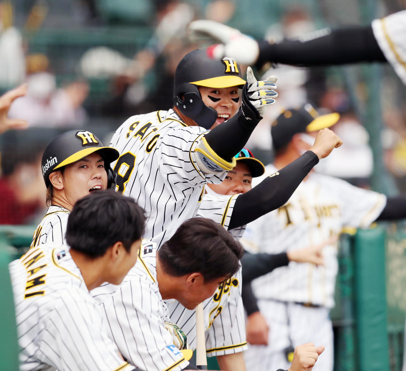 阪神対DeNA 7回裏阪神1死二、三塁、佐藤輝は同点中犠飛を放った大山を笑顔で指さす（撮影・加藤哉）