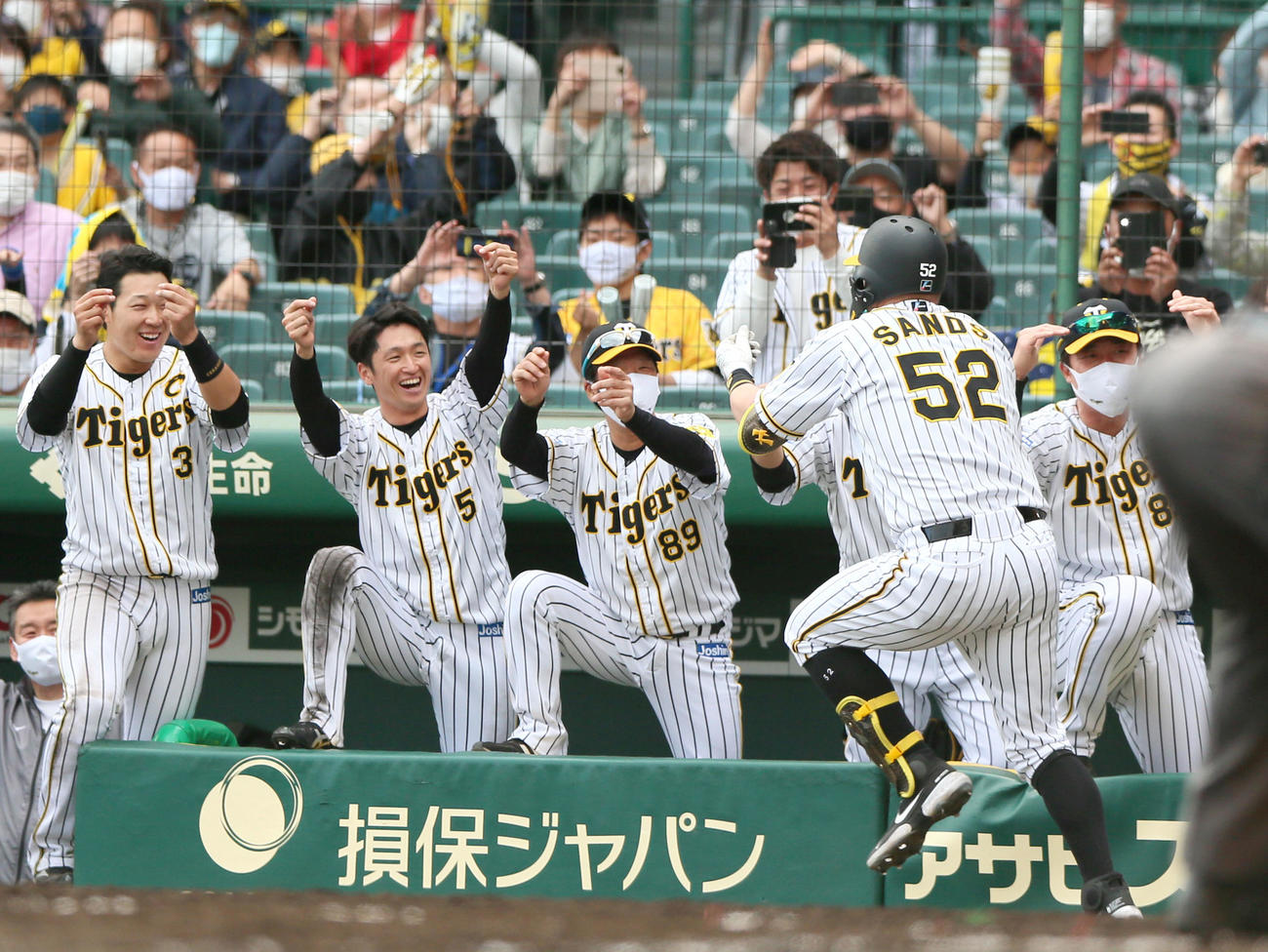 阪神対DeNA 7回裏阪神2死三塁、矢野燿大監督（左から2人目）は中越え2点本塁打を放ったサンズ（左から4人目）をハッピーハンズで出迎えるベンチの選手ら（撮影・上山淳一）
