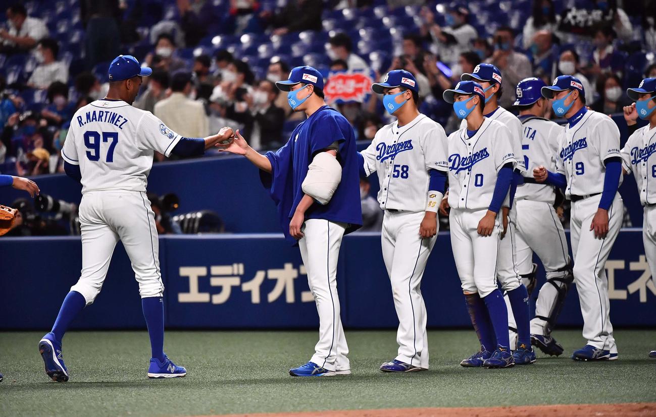 中日対阪神　今季初勝利を挙げた大野雄（左から2人目）は、最後を締めたマルティネス（左）から勝利球を受け取る（撮影・上田博志）