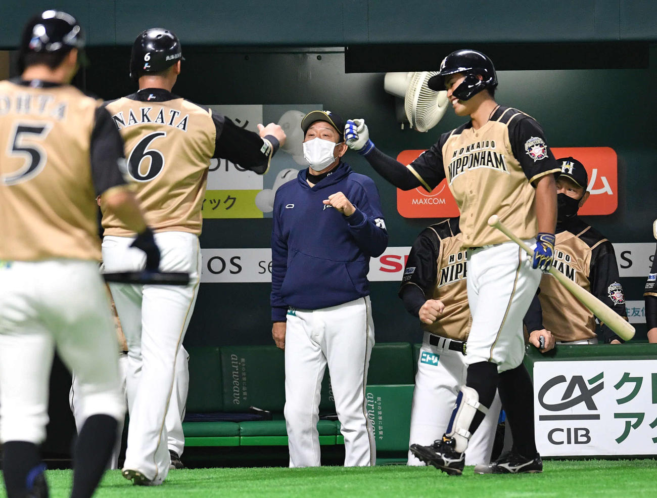 ソフトバンク対日本ハム　1回表日本ハム2死一、二塁、渡辺の先制中前適時打で生還した中田（左から2人目）を迎える栗山監督（中央）と今川（撮影・岩下翔太）